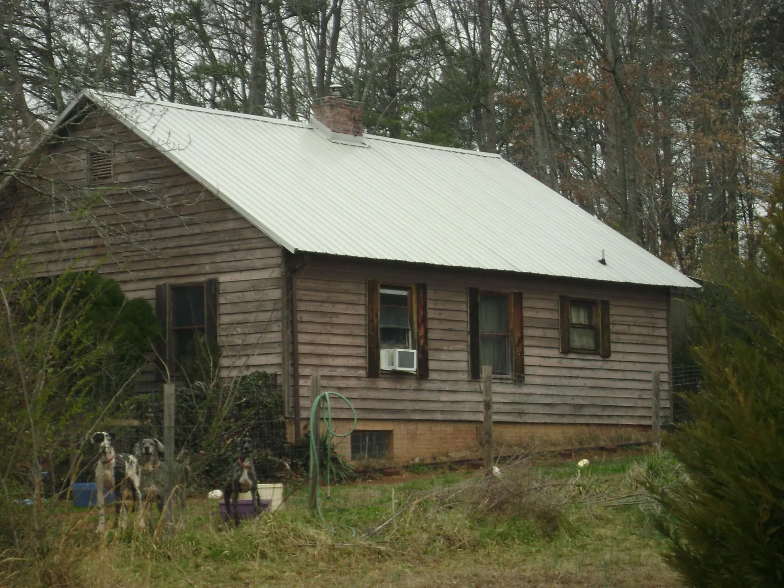 White metal roof on an old wood sided farmhouse, from a Metal Roof Installation job in Mc Lean